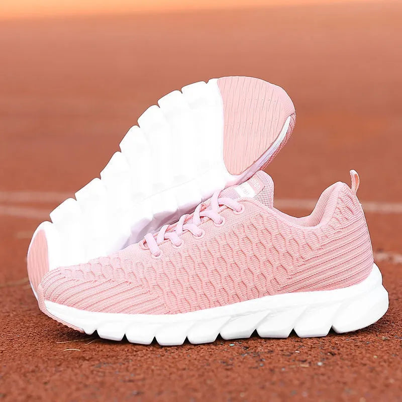 Women's fly knit running shoes in black, pink, or white colours, showing the woven upper and durable outsole.