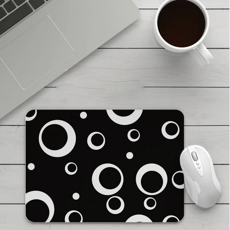 Custom cartoon thickening mouse pad on a desk, showing a colourful design with black stitched edge.