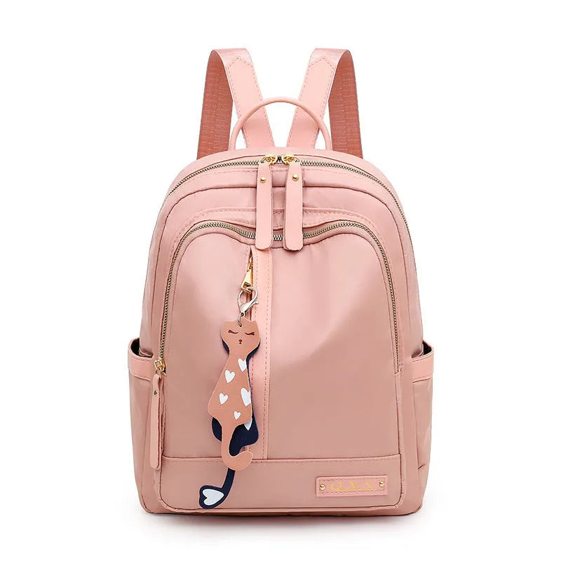 Black nylon casual travel backpack with double shoulder straps, external pockets, and a soft handle on a solid background.