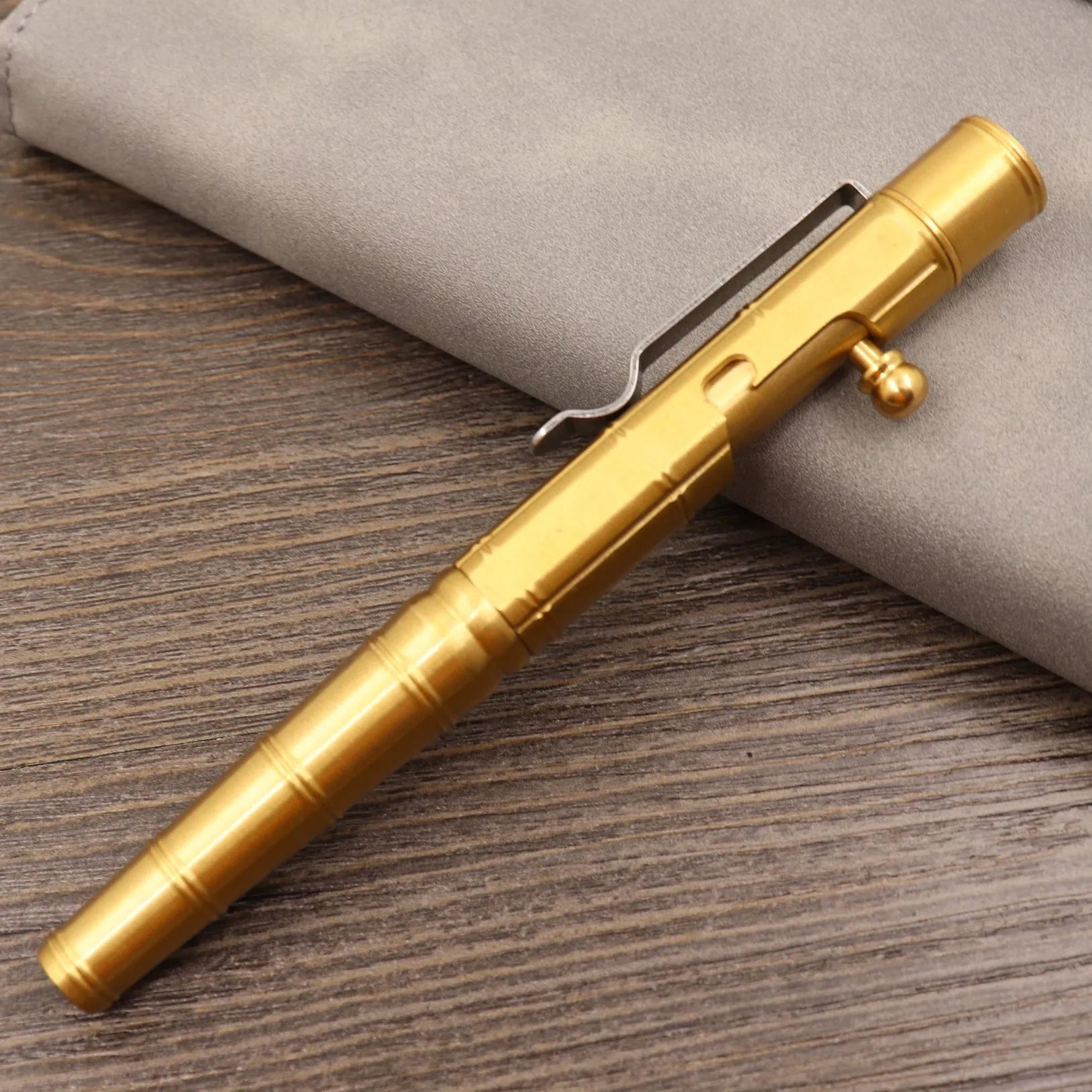 Retro brass tactical pen with press bolt-action mechanism and cylindrical metal barrel