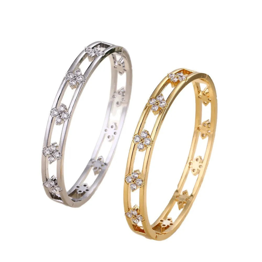 Gold or silver adjustable hollow bracelet with a four-leaf clover charm inlaid with a zircon stone.