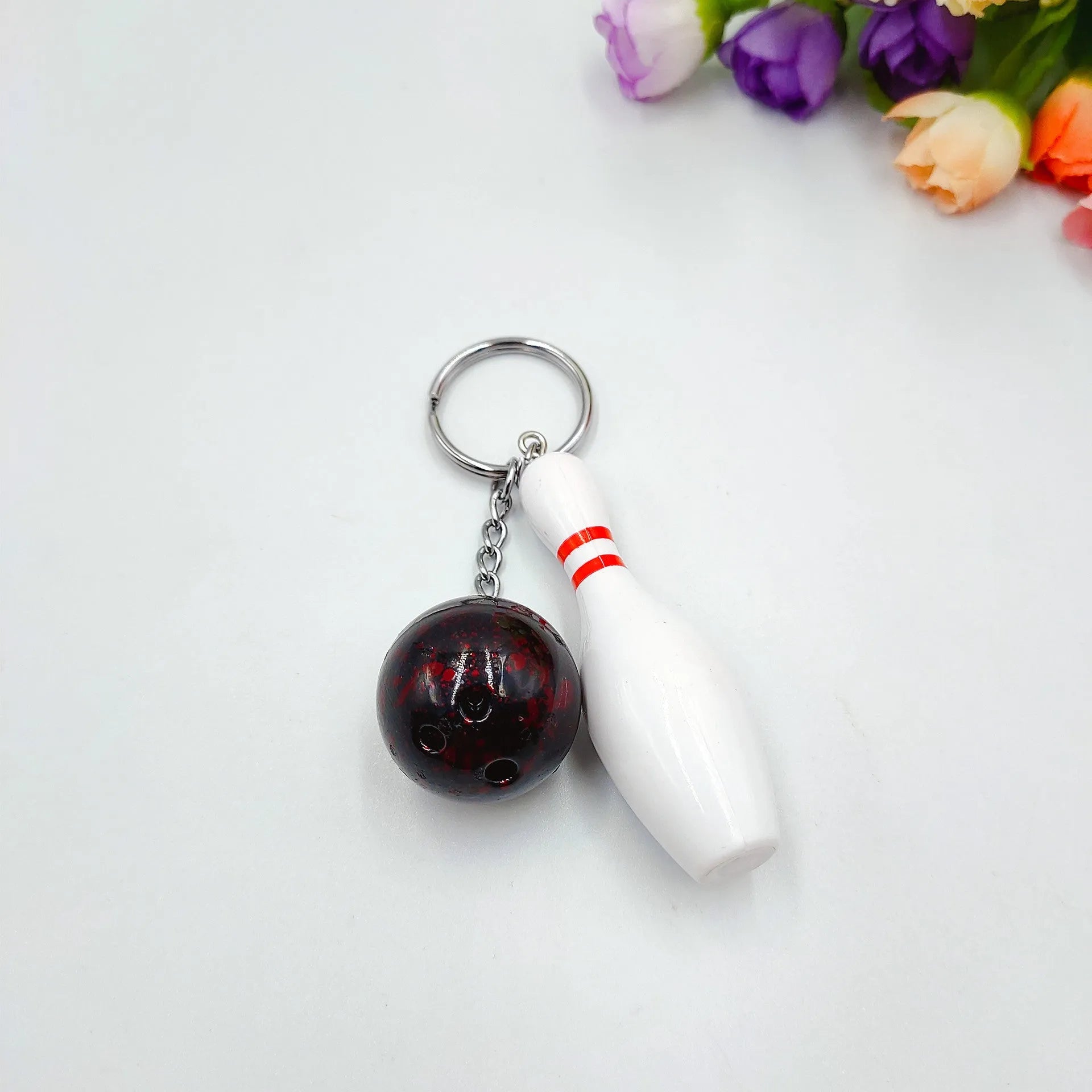 Mini sports bowling keychain pendant in PVC metal, shown in dark red, blue, purple, and green colour options.