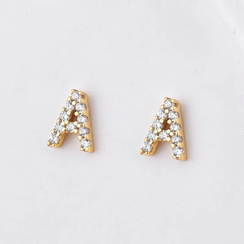 Gold-plated brass alphabet earring showing a single letter with zircon detail on a copper base.