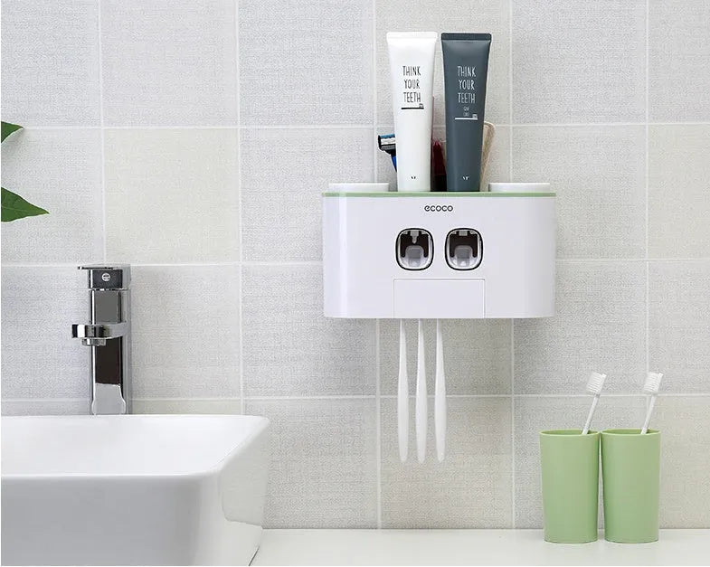 Plastic wall-mounted toothbrush holder with four magnetic cups in pink, blue, and green for family bathroom