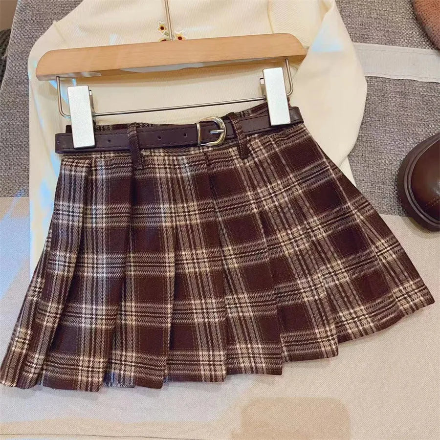 Girls red and black plaid pleated A-line skirt with a cotton lining, shown on a hanger.