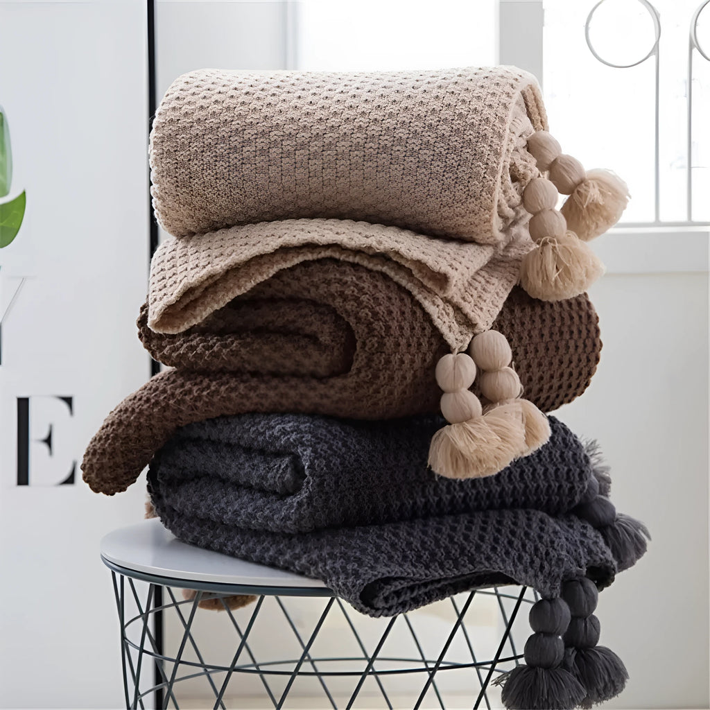 Nordic fringe knit ball blanket in beige colour on sofa, showing 130×170cm dimensions and fringe detailing.