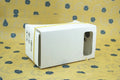 Pink and white flat-pack VR cardboard glasses viewer for 6-inch mobile phones.