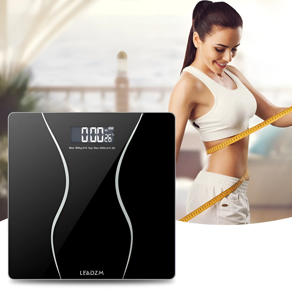 Black electronic digital bathroom scale on a tiled floor showing weight display.