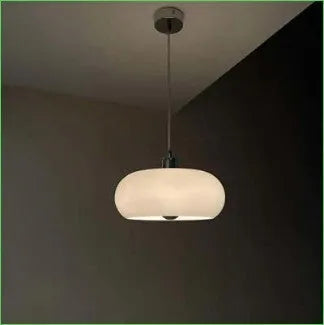 Three-headed Bauhaus pendant light with milky white glass egg tart shades hanging from a ceiling.