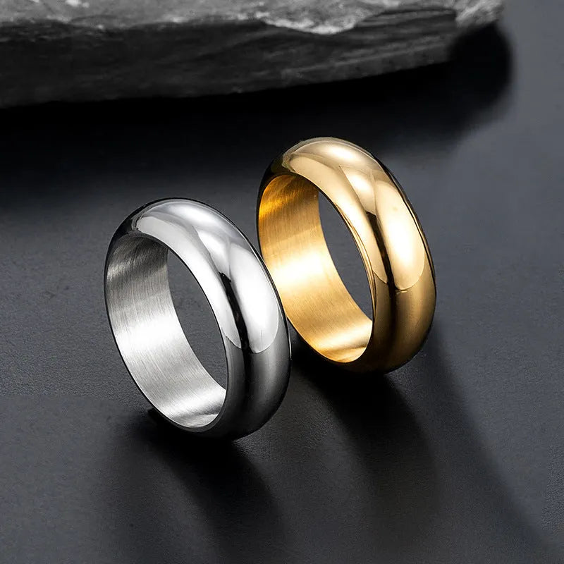 Glossy electroplated titanium steel ring shown in gold, black, and steel colour finishes on a grey background.
