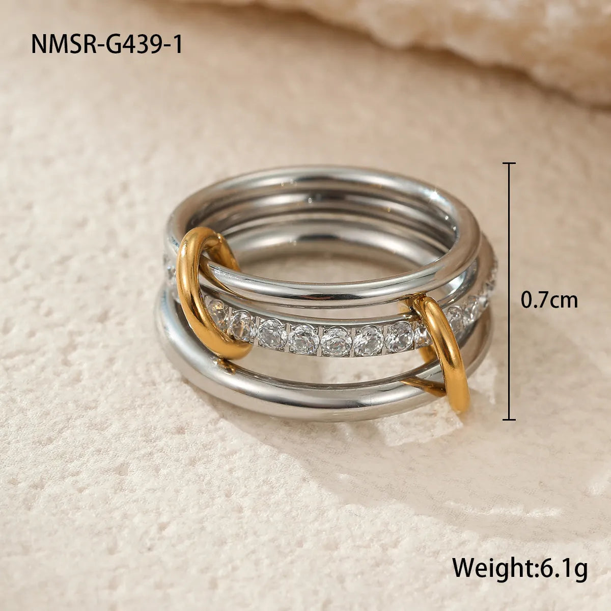 Stacked gold plated stainless steel ring set showing exaggerated design on a model's hand.