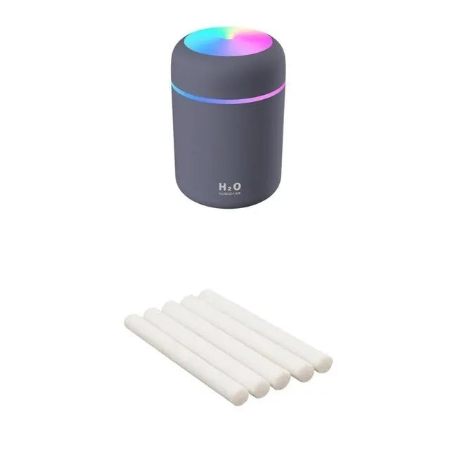 Pink USB mini humidifier with LED lights and water tank on desk