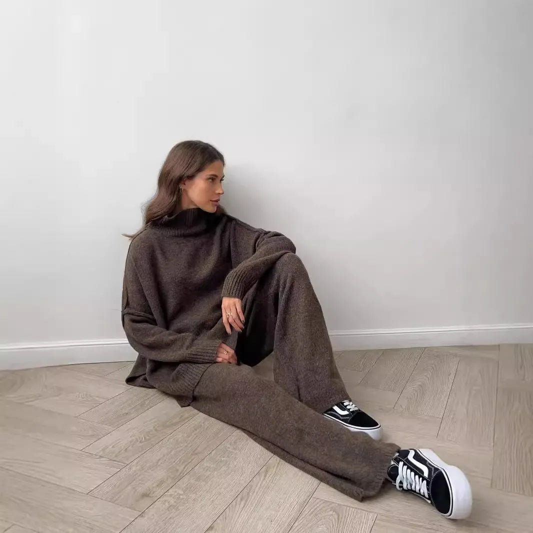 Women's dark grey knit co-ord suit with side-slit sweater and matching trousers laid flat.