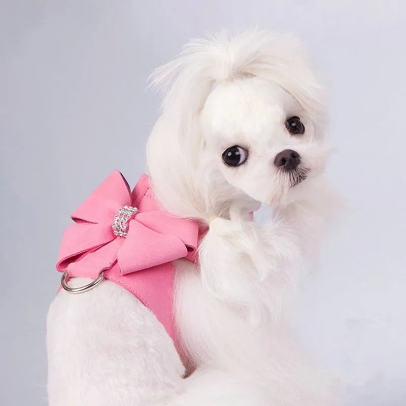 A pink microfiber dog chest strap with a large decorative bowknot, shown alongside blue and orange colour options.