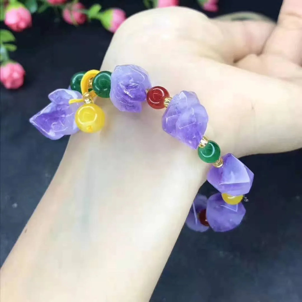 Close-up of a purple natural amethyst bead bracelet with a fu charm for women, on a white background.