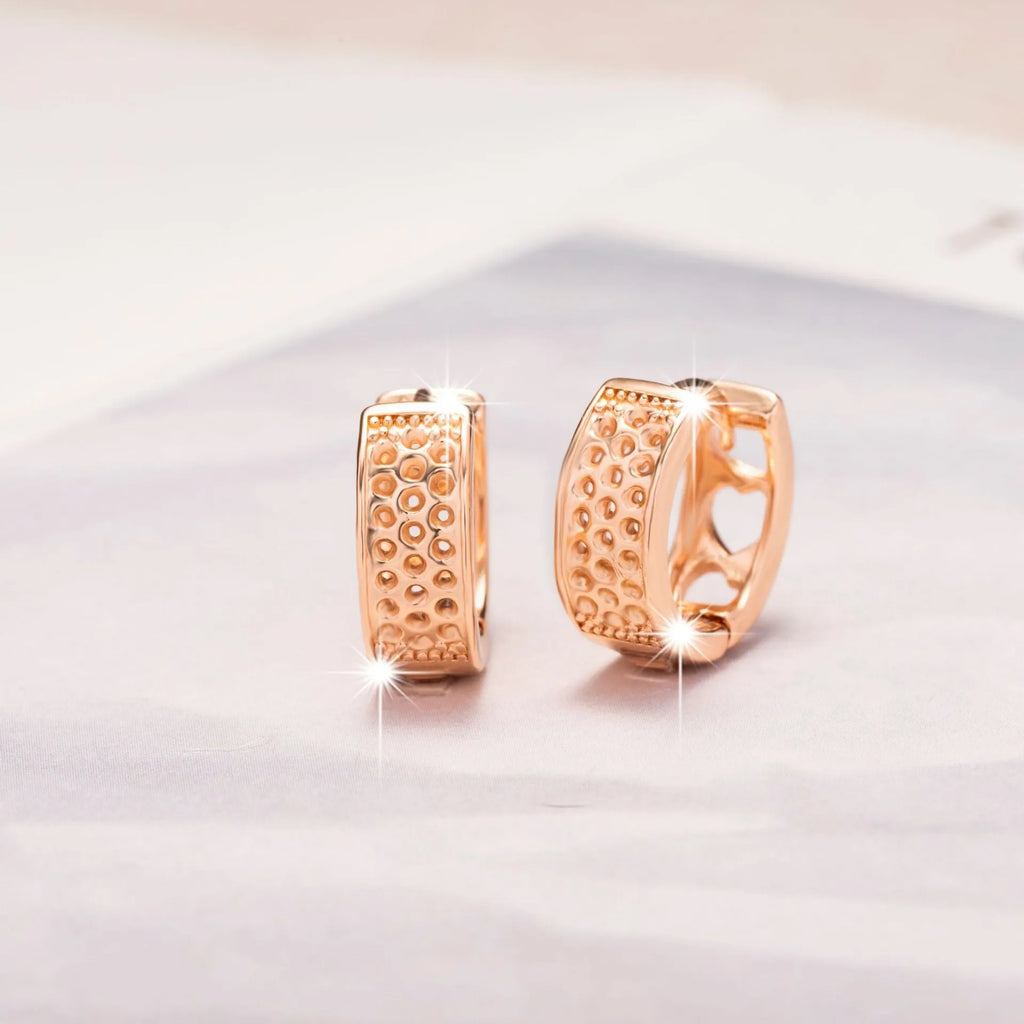Rose gold women's earrings with three hollowed heart shapes in circular design