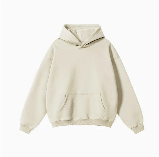 Man wearing a loose-fit cotton terry hooded sweater with drop-shoulder sleeves in a solid colour.
