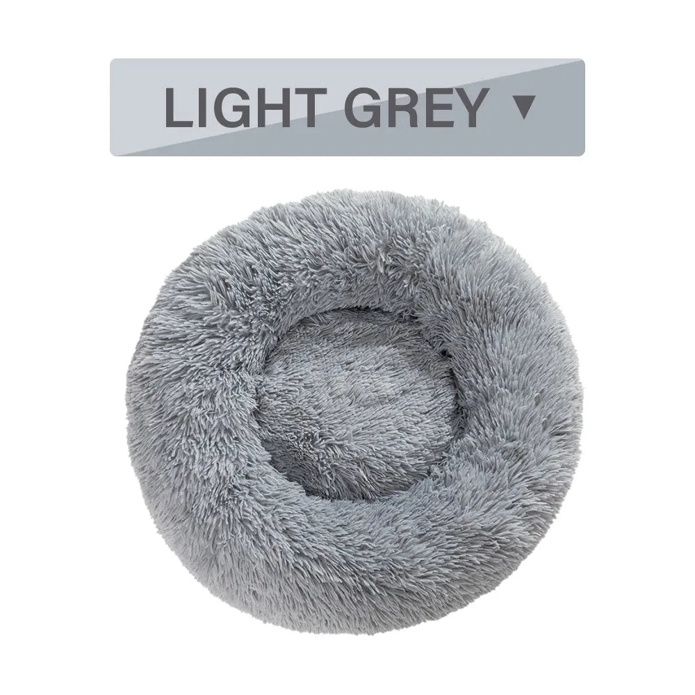 Fluffy donut-shaped pet bed in long plush fabric, shown in a light grey colour.