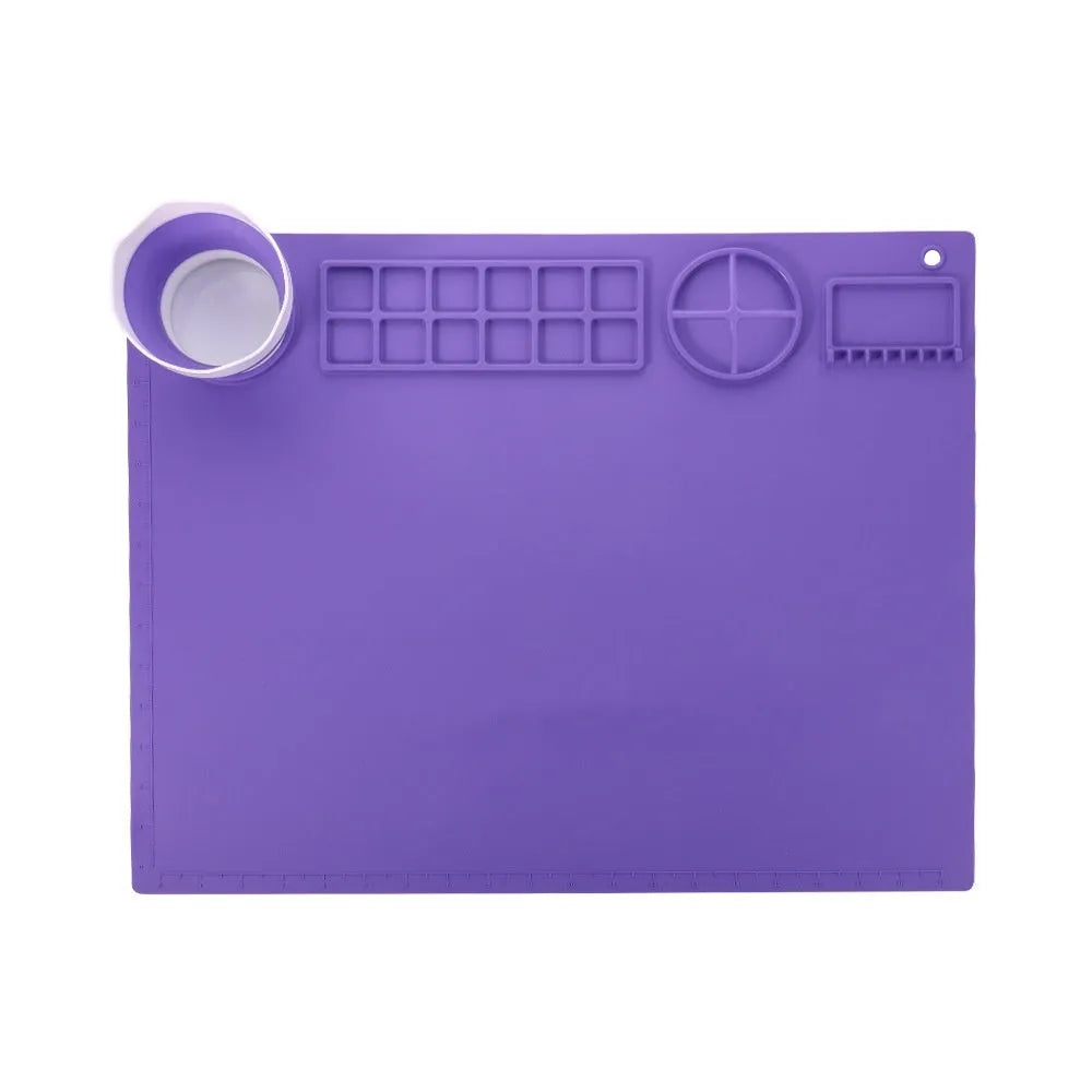 Green silicone painting mat measuring 50 by 40 centimetres with two round bowl wells for holding water or paint.