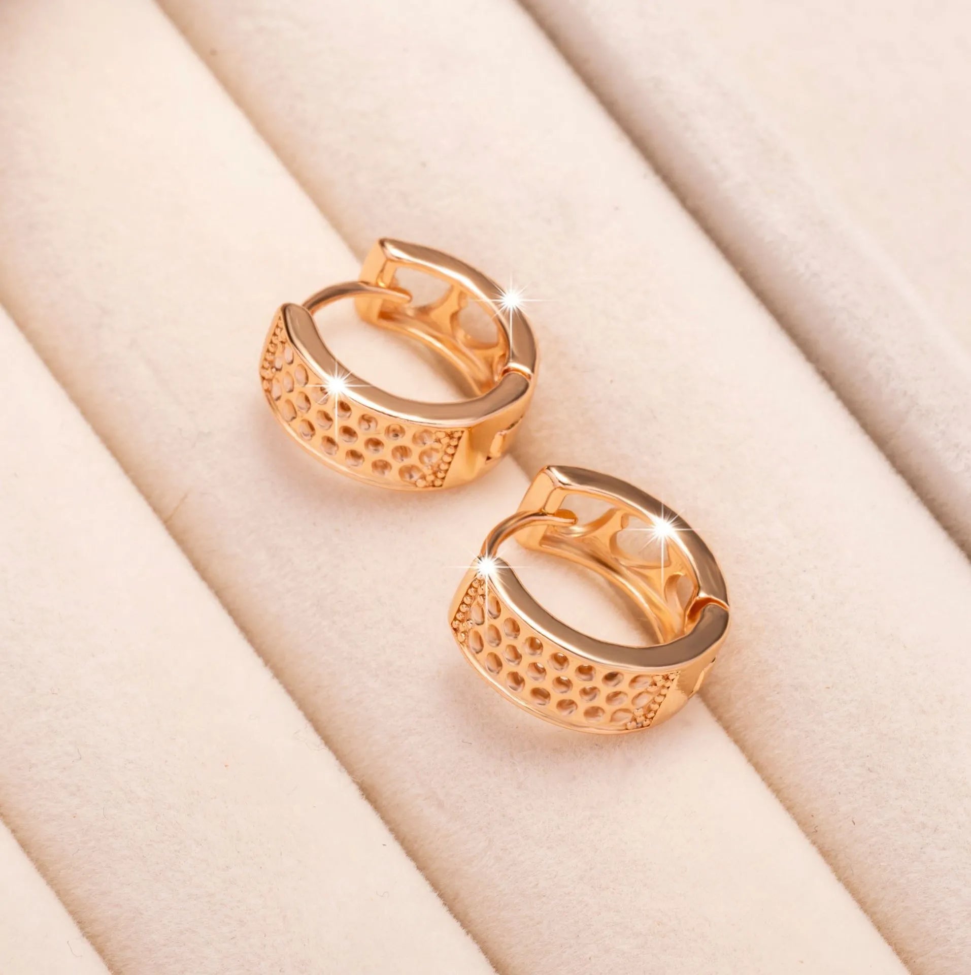 Rose gold women's earrings with three hollowed heart shapes in circular design