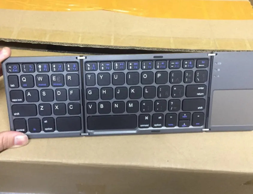 Tri-fold folding Bluetooth keyboard shown in both unfolded typing position and folded portable configuration