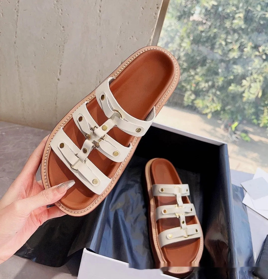 Women's brown patent leather Roman sandal slippers with sheepskin upper on a white background.
