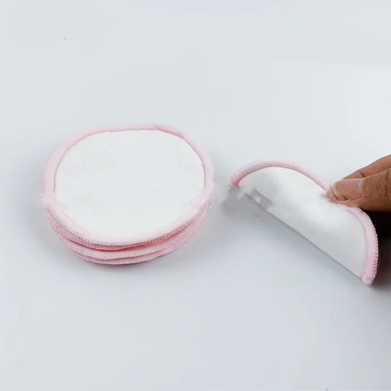Set of eight pink and blue velvet makeup remover pads next to an organic cotton mesh drawstring bag.