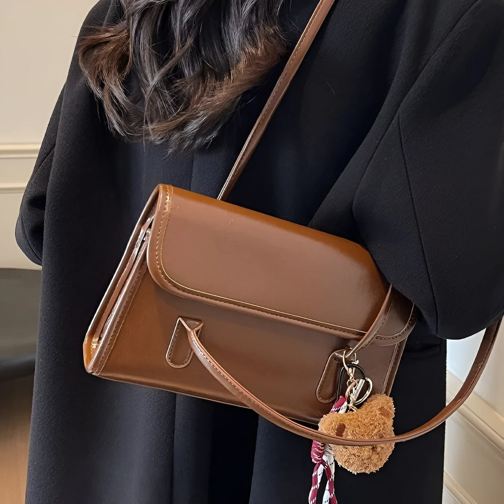 Brown women's structured square PU leather shoulder bag with a detachable tassel pendant and double straps.