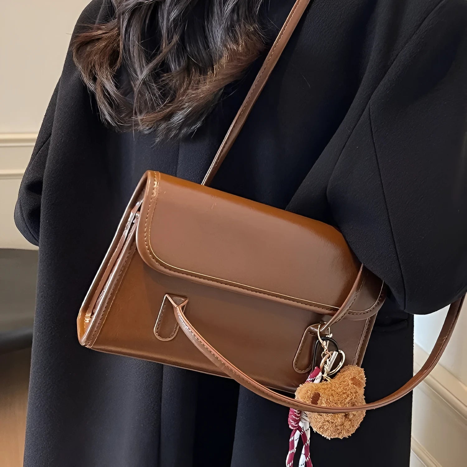Brown women's structured square PU leather shoulder bag with a detachable tassel pendant and double straps.