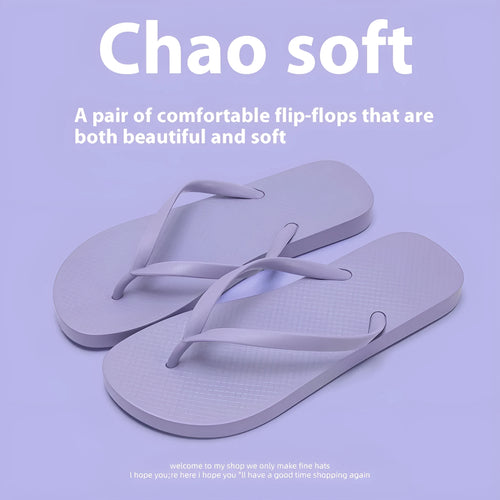 Orange foldable beach slippers with a hollow-out plastic upper and non-slip PVC sole on a sandy background.