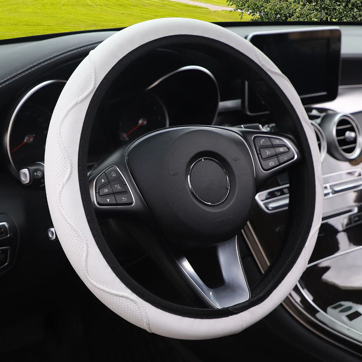 Black elastic steering wheel cover with a corrugated texture, stretched to show its fit.