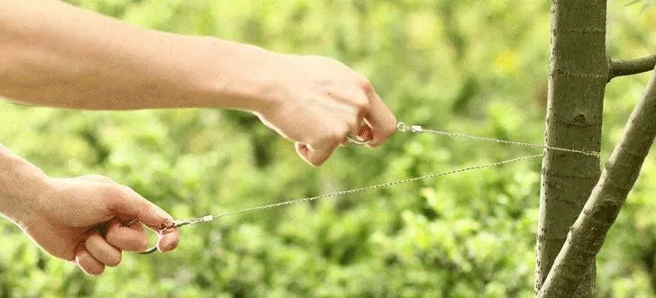German stainless steel survival wire saw coiled up, showing its four-strand construction and compact size.