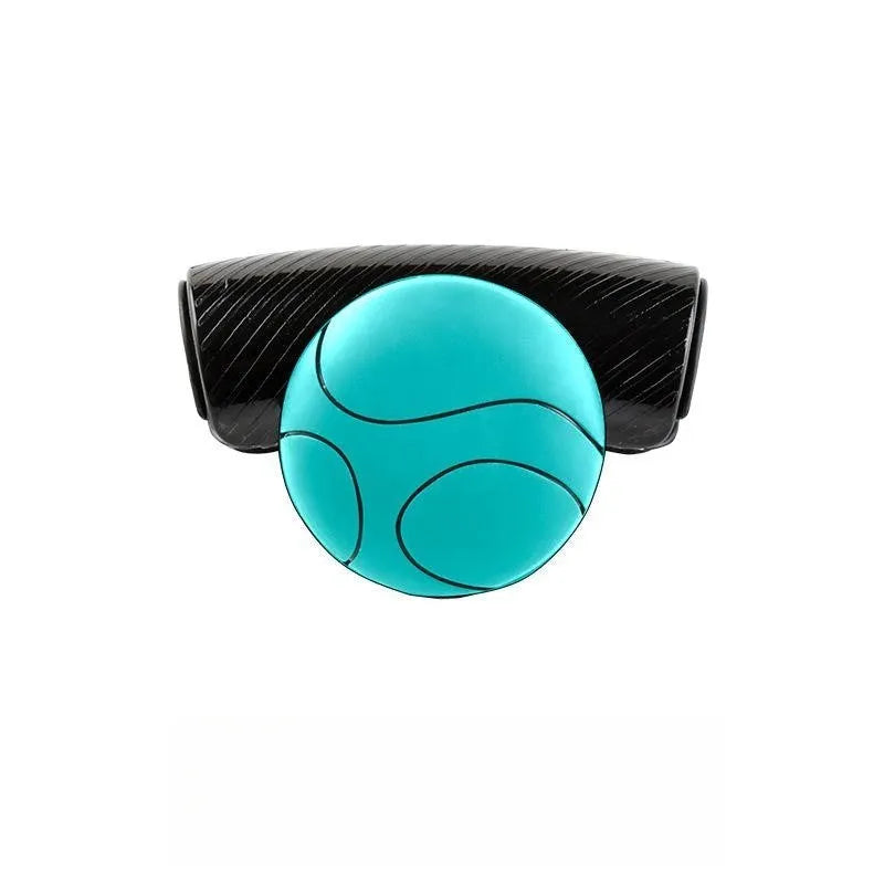 Close-up of black silicone steering wheel assist ball with metal bearing mechanism attached to a car steering wheel rim