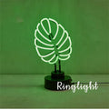 Creative minimalist bamboo-shaped desk lamp with green light on a white background.