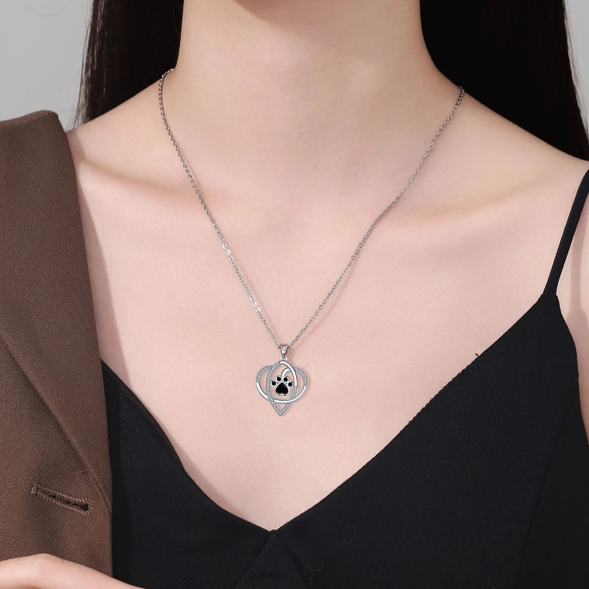 Silver tone dog and cat paw print necklace with cross chain design