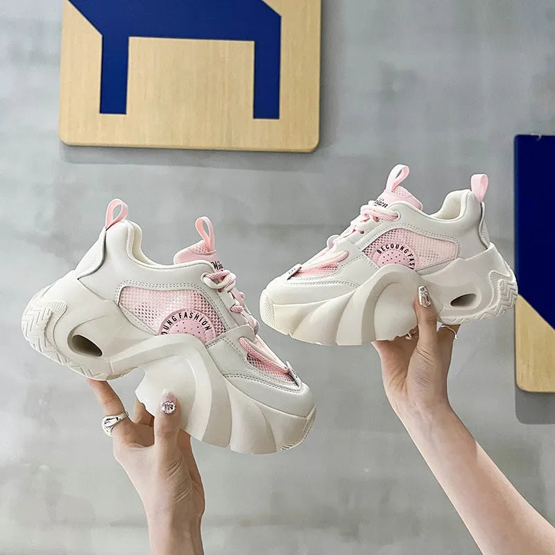 Women's beige platform sneakers with a cross-strap design and thick sole.