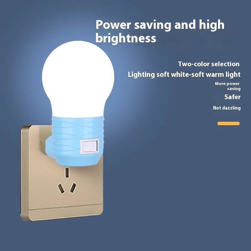 Plug-in bedside baby night light in white, blue, or pink shell with round design on a table
