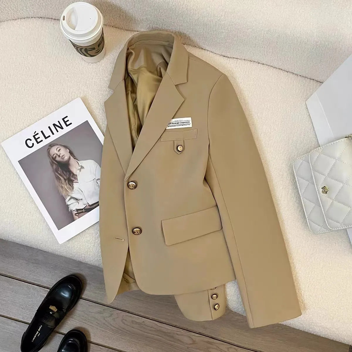 Women's black loose-fit short suit coat with long sleeves and pocket details.