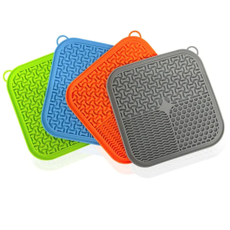 Square orange-red and grey silicone dog lick mat with textured surface and suction cups on the back.