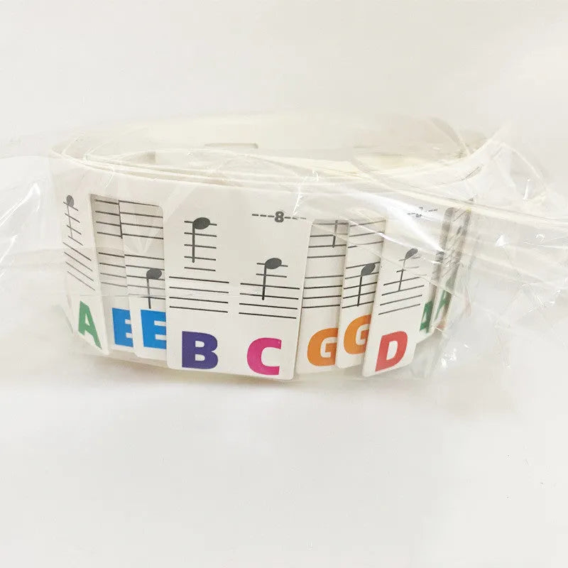 Two bags of white card piano keyboard stickers for 88 keys, showing colour note bar and black note designs.