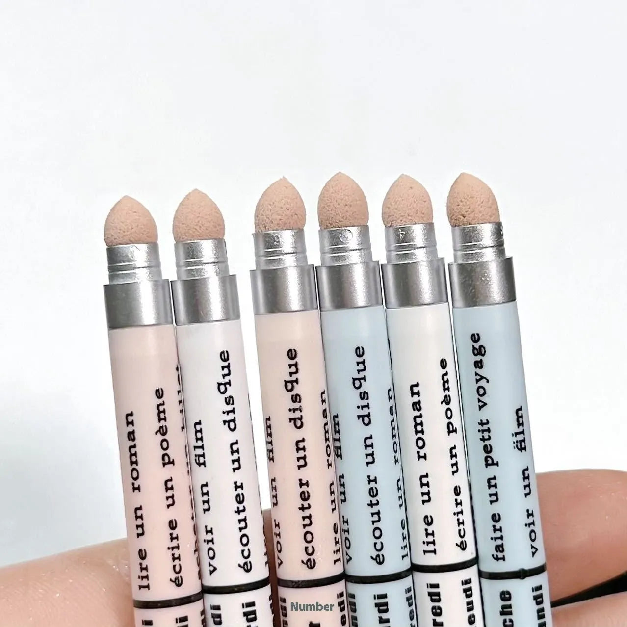 Waterproof 2-in-1 eyeshadow and highlighter pen in assorted colours on a white background.
