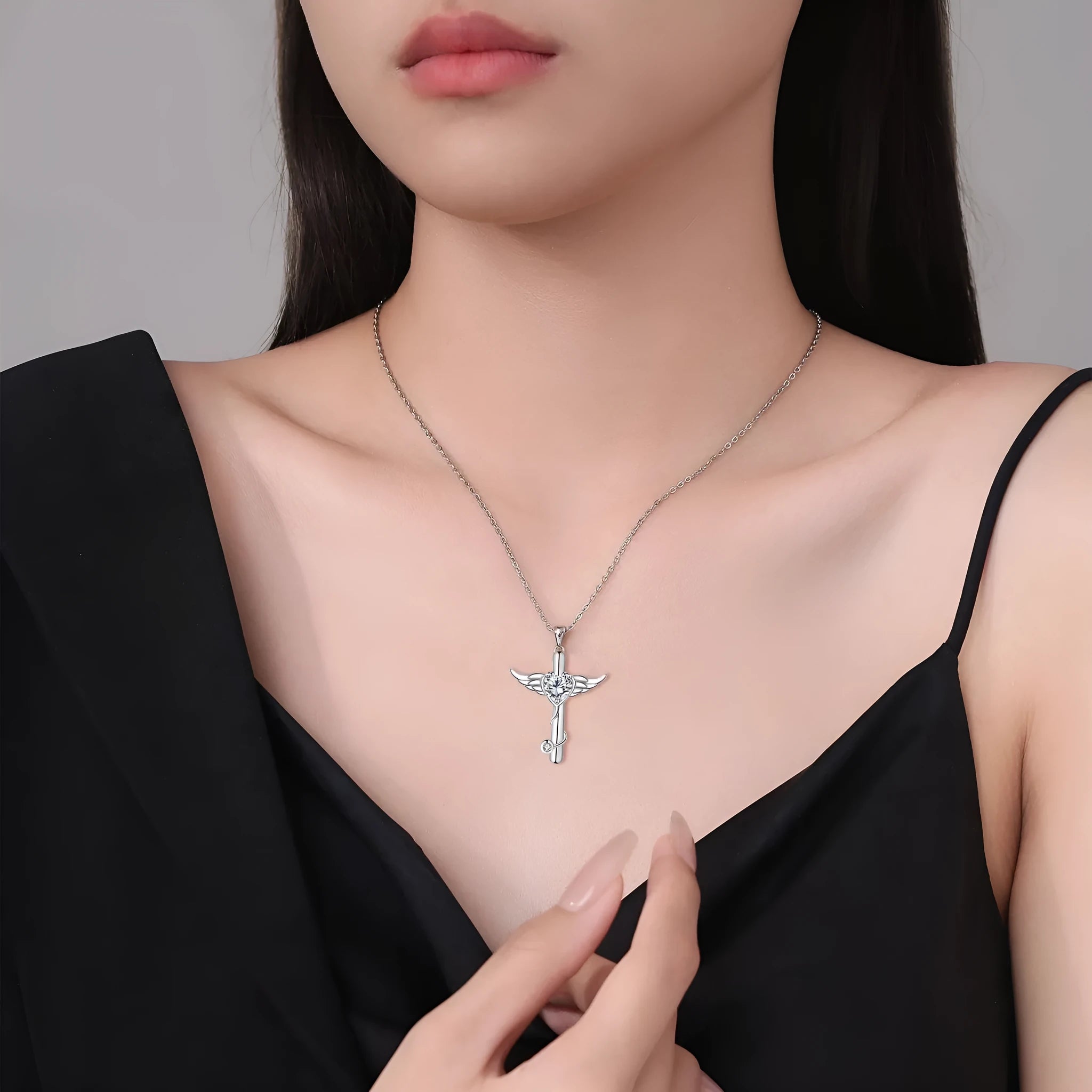 Close-up of a copper wings cross stethoscope pendant necklace on a chain.