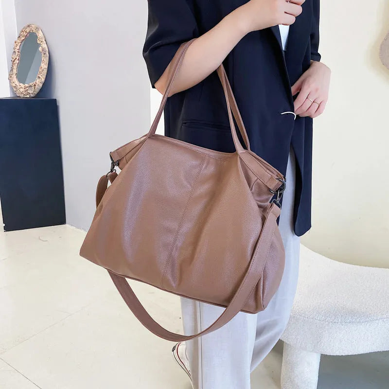 Large soft PU leather messenger bag in khaki colour with adjustable shoulder strap and top handle.