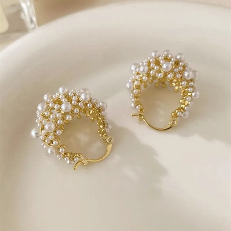 Gold-coloured copper flower basket earrings with small rice-shaped bead inlay detail.