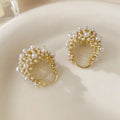 Gold-coloured copper flower basket earrings with small rice-shaped bead inlay detail.