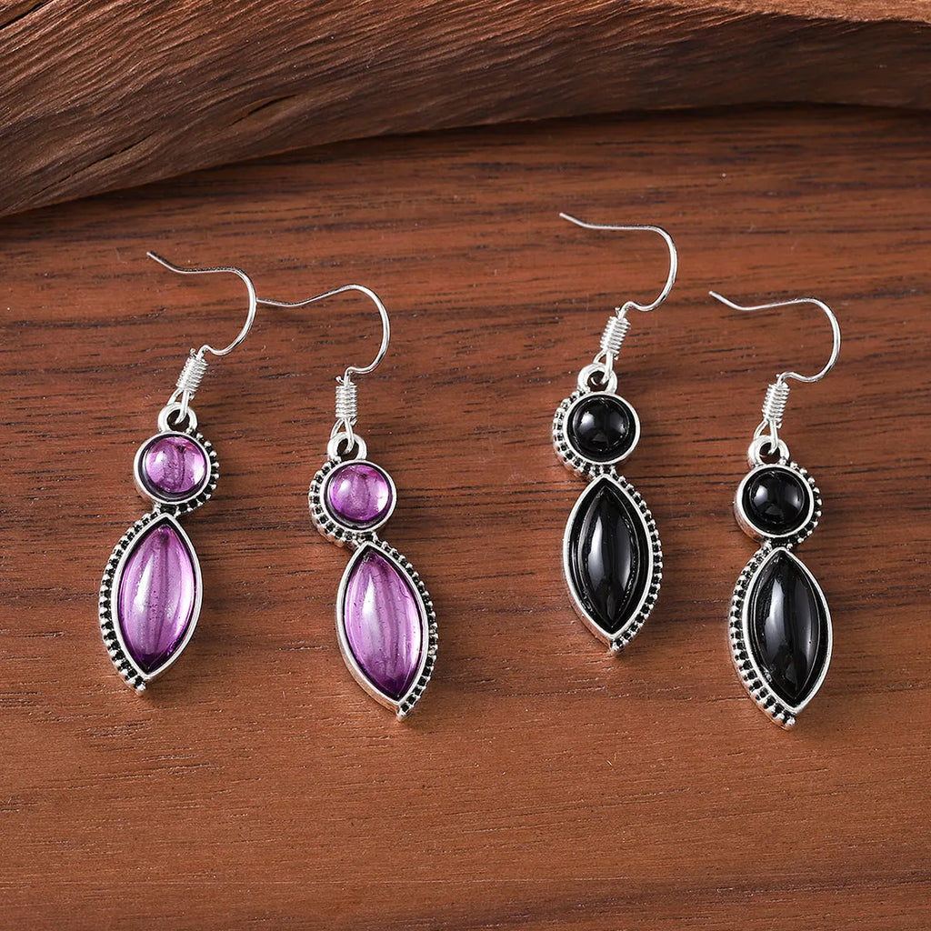 A pair of black and purple vintage geometric pendant earrings with bohemian style on a white background.