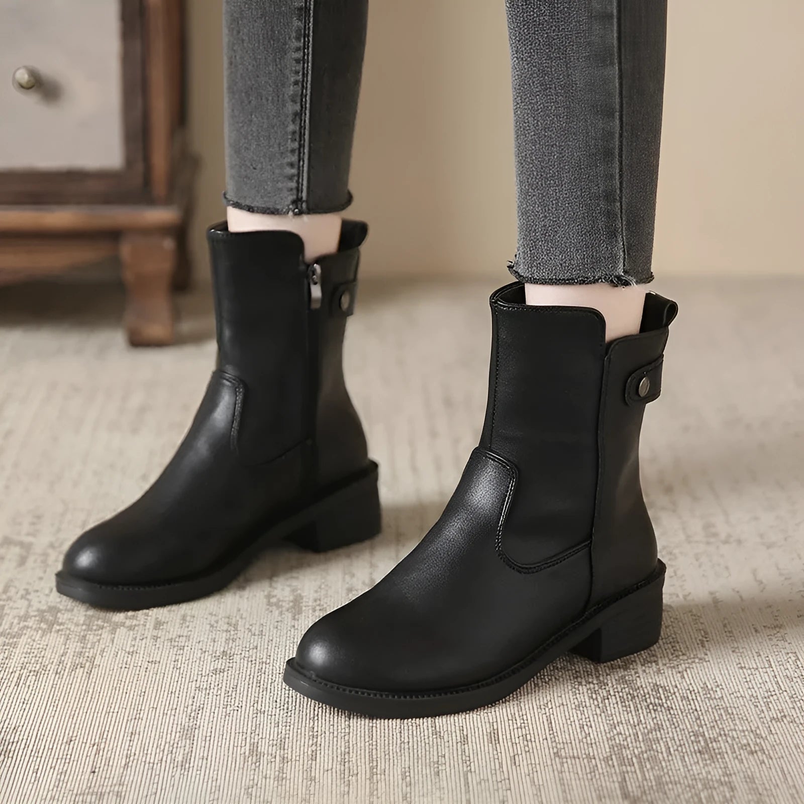 Black women's low heel ankle boots with a side zipper and round toe.
