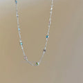Square artificial crystal pendant on a fine gold clavicle chain necklace.