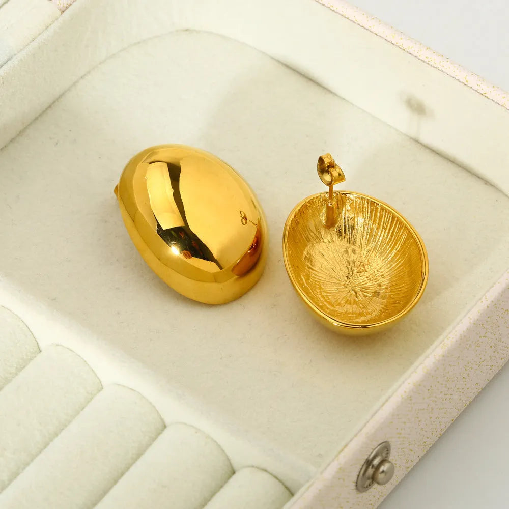 Close-up of simple geometric stainless steel stud earrings with 18K gold plated glazed finish and line design.