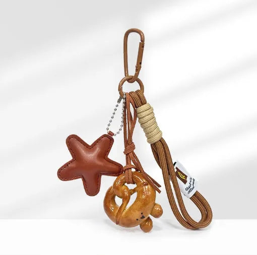 Handbag pendant charm with handmade soda bread design patterns including brown star, croissant, and bagel